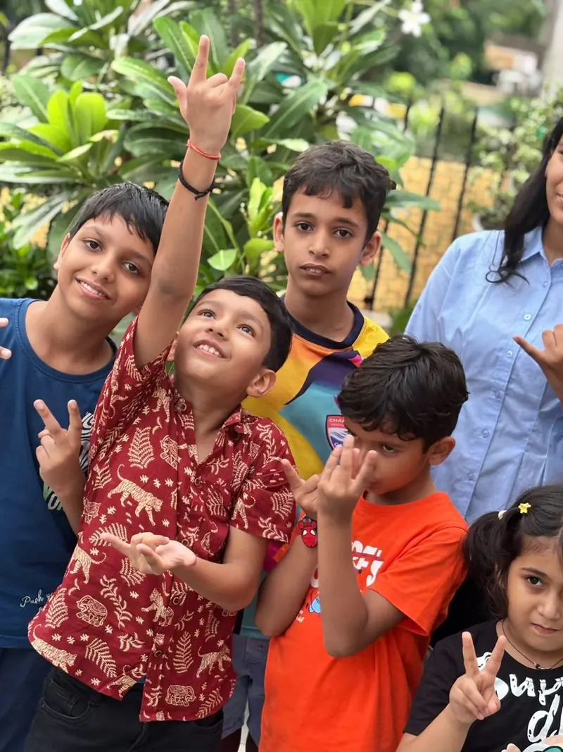Children cheering with their TalkTheTalk teacher outdoors
