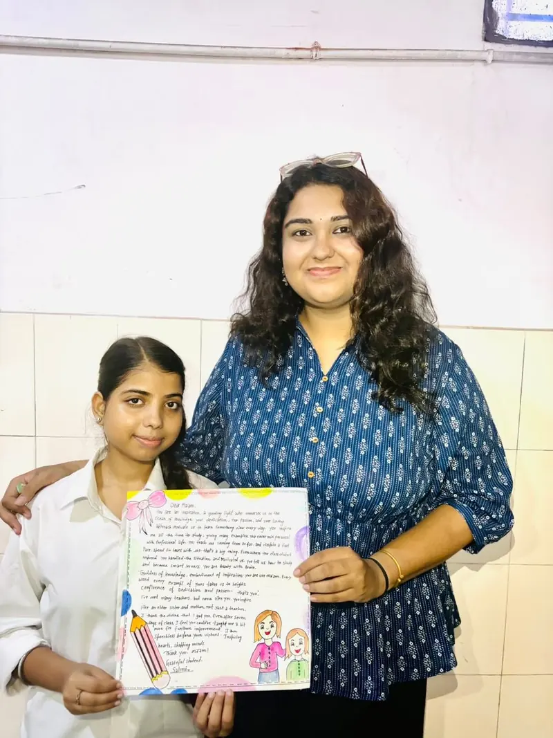 A TalkTheTalk teacher with a student holding a handwritten letter